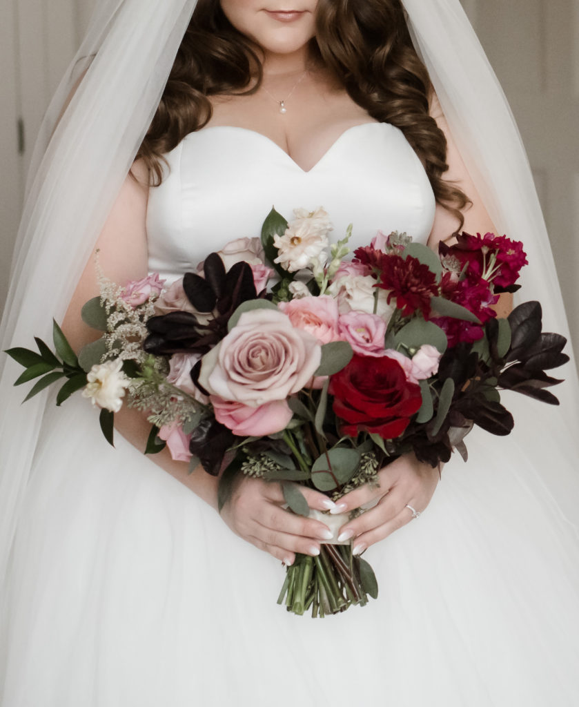 A woman holds a bridal bouquet for her Graydon Hall wedding.
